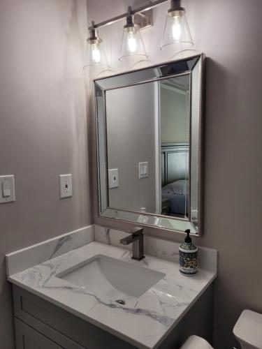 bagno con lavandino e grande specchio di Jackzhang a Aurora