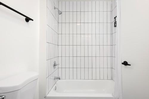a bathroom with a shower with white tiles at Fenix Hotel Hollywood in Los Angeles