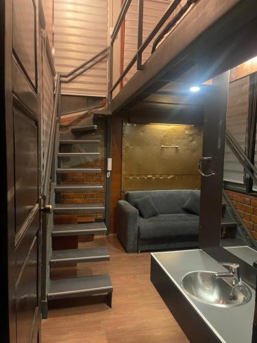 a living room with a couch and a sink and stairs at Onkel Inn Wagon Sleepbox Uyuni in Uyuni