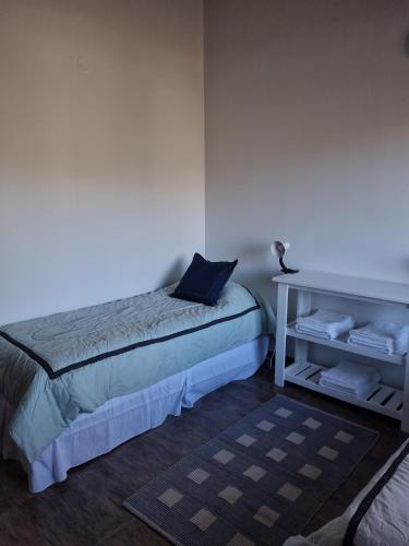 a bedroom with a bed and a table with towels at Los Reales in Esquel