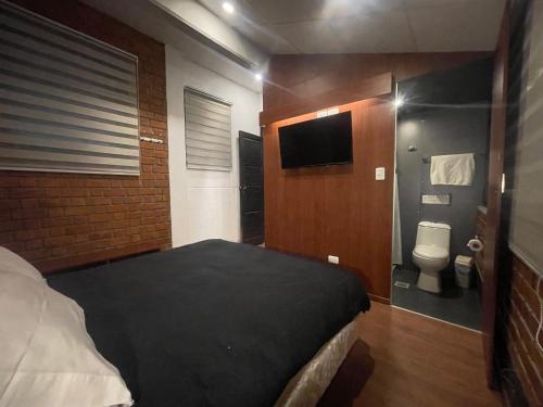 a bedroom with a bed and a bathroom with a toilet at Onkel Inn Wagon Sleepbox Uyuni in Uyuni