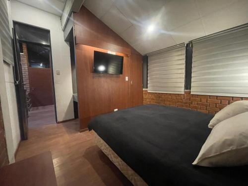 a bedroom with a bed and a tv on the wall at Onkel Inn Wagon Sleepbox Uyuni in Uyuni