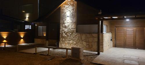 a house with a wooden door and a stone pillar at Los Reales in Esquel