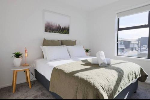 um quarto branco com uma cama grande e uma janela em CBD with Style and Luxury - Free Parking em Christchurch