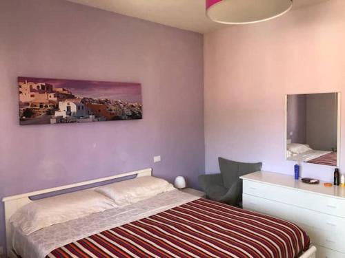 Un dormitorio con una cama y un televisor en la pared. en Mar-Vada Apartment Relax at the Tuscany coast, en Vada