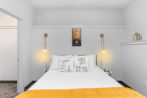 a bedroom with a white bed with an orange blanket at Skywalker Rebel Base in Seattle