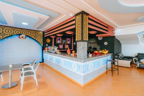 a restaurant with a counter with a table and chairs at Lacasa latifa in Moulay Bousselham