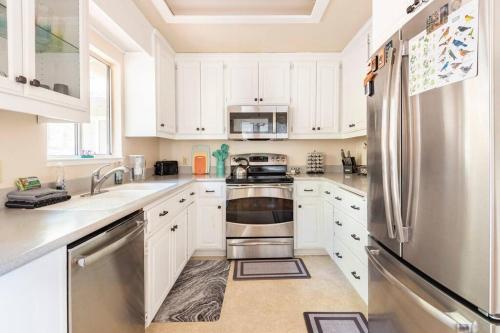 a kitchen with white cabinets and a stainless steel refrigerator at Murphys Wine Country Getaway in Murphys
