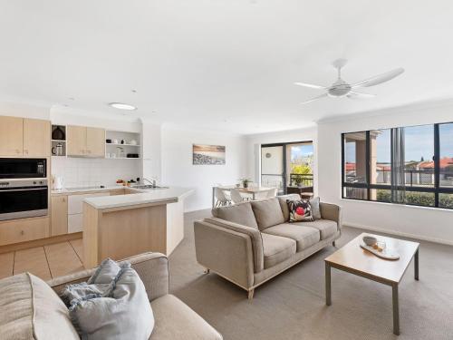 a living room with two couches and a kitchen at Villa 51 - The Sands Resort in Yamba