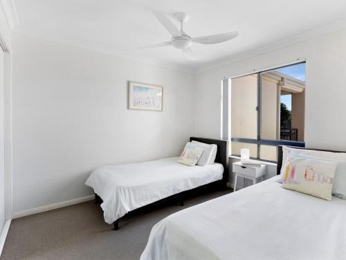 a bedroom with two beds and a ceiling fan at Villa 51 - The Sands Resort in Yamba