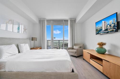 Panoramic views 1 bed Beach Walk 27th Miami في هوليوود: غرفة نوم بيضاء بها سرير ونافذة