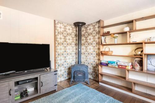 a living room with a tv and a wood stove at Murphys Wine Country Getaway in Murphys