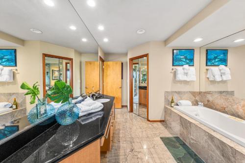 a bathroom with a large tub and a sink at Kaanapali Plantation 57 in Lahaina