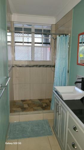 een badkamer met een douche en een wastafel bij Valley View in Roseau
