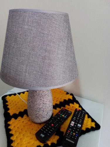 a lamp and two remote controls on a table at Hospedagem Frez in Nova Friburgo