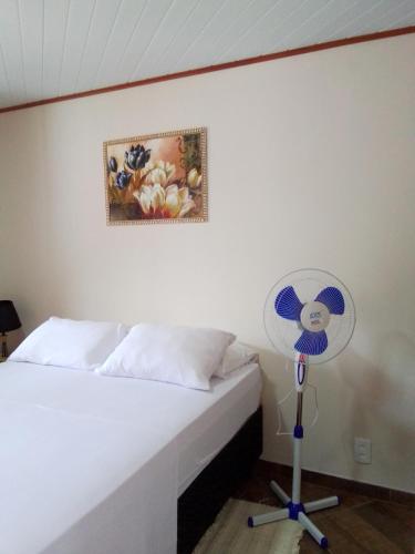 a bedroom with a white bed and a fan at Hospedagem Frez in Nova Friburgo