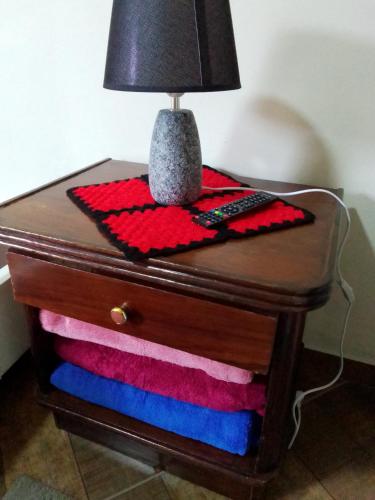 a table with a lamp on top of a drawer at Hospedagem Frez in Nova Friburgo