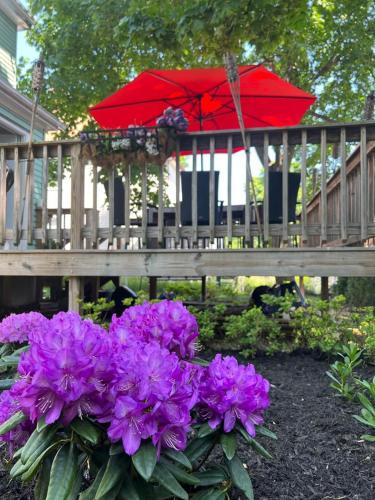 a table with a red umbrella and purple flowers at Private Room in a Grand House in Boston