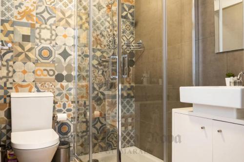 a bathroom with a shower and a toilet and a sink at Casa Porta Nova AL in Guimarães