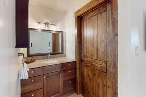 a bathroom with a sink and a wooden door at Pine Haven Retreat in Stateline