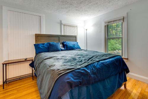 een slaapkamer met een bed met blauwe lakens en een raam bij Quiet Wells Vacation Rental with Yard, Near Beach! in Wells