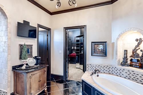 a bathroom with a large tub and a walk in closet at Lubbock Luxury Living in Lubbock
