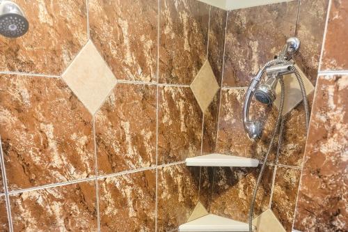 y baño con ducha y azulejos marrones. en Waterside Retreat, en Cleburne