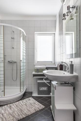 a white bathroom with a sink and a shower at Luxury villa with a swimming pool Split - 20334 in Solin