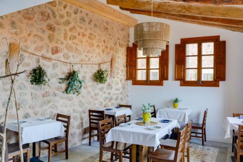 a dining room with white tables and chairs at Can Colom in Banyalbufar