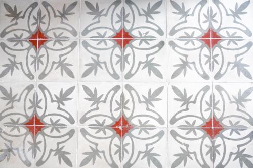 a tile floor with a pattern of red and black at Can Colom in Banyalbufar