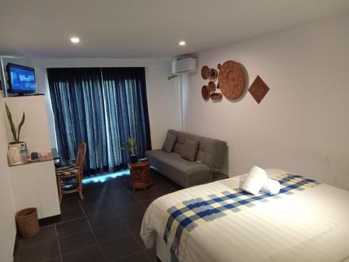- une chambre avec un lit, un canapé et une fenêtre dans l'établissement Taman Unique Hotel, à Senggigi