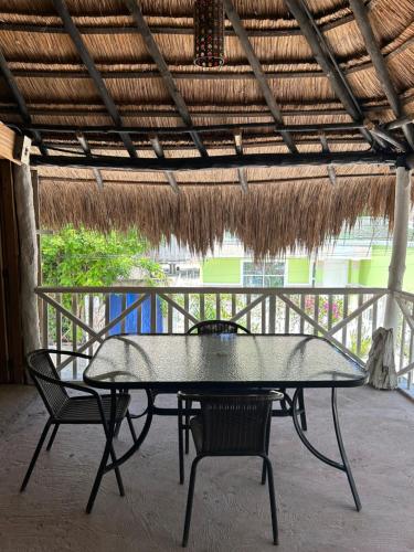 una mesa y dos sillas bajo un techo de paja en Eco-Conscious Oasis Punta Arena 01, en Playa Punta Arena