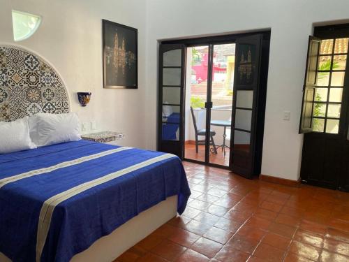 a bedroom with a bed with a blue blanket at Casa Yollotzin in Ajijic