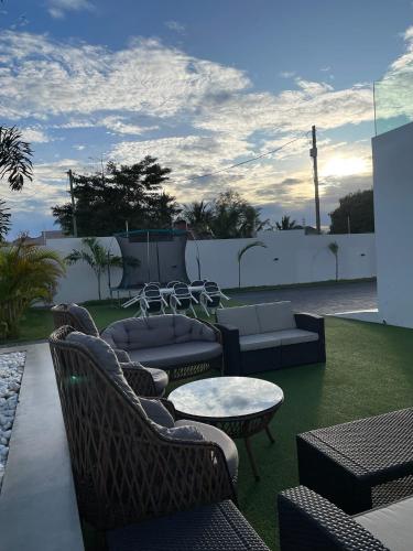 a patio with couches and a table and chairs at Kibada White Villa in Dar es Salaam