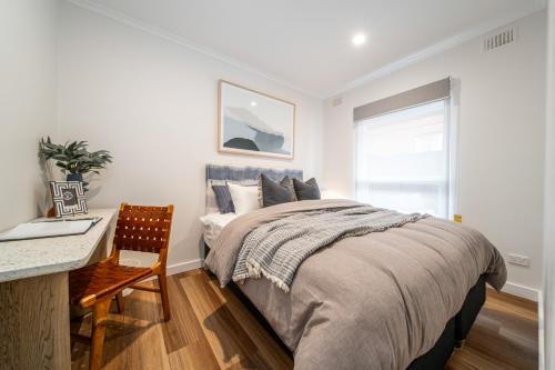a bedroom with a bed and a desk and a window at The Tea House - Apartment 1 in Keswick