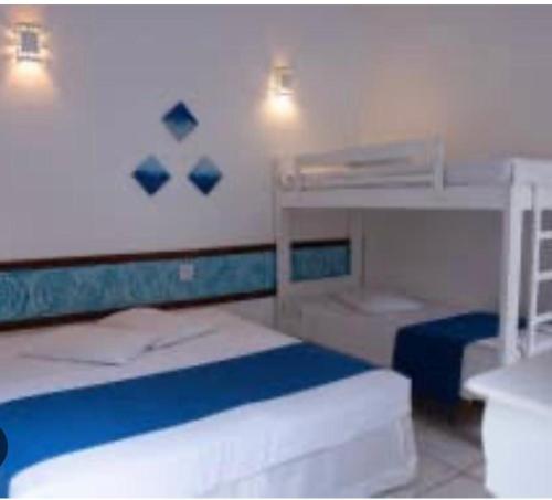 a bedroom with two beds and a bunk bed at Villa dos anjos in Olímpia
