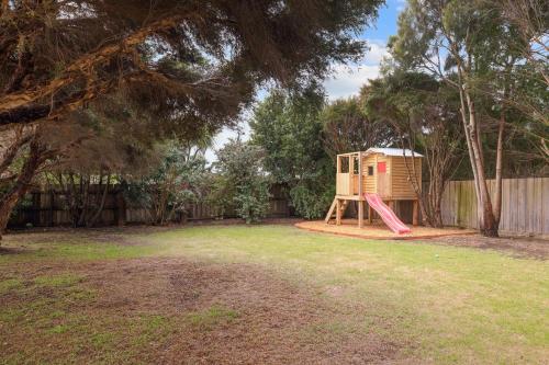 a playground in a yard with a house at Lazy Daze at SummerHaze in Cape Woolamai