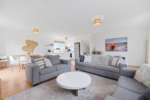 a living room with two couches and a table at Lazy Daze at SummerHaze in Cape Woolamai