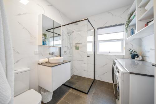 a white bathroom with a shower and a toilet at The Tea House - Apartment 2 in Keswick