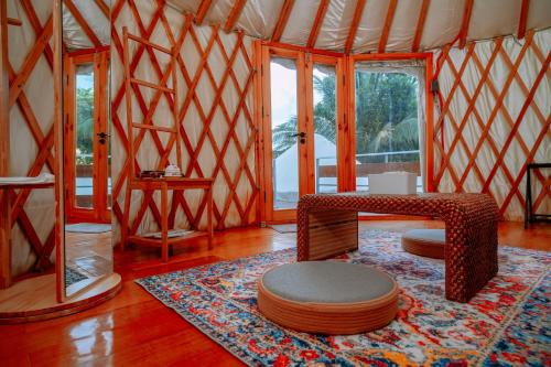 Habitación con una yurta con mesa y alfombra en Nomad Yurts en Corón