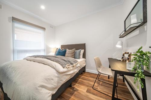 a bedroom with a bed and a desk and a window at Two Tea House - Contemporary Courtyard Comfort in Keswick