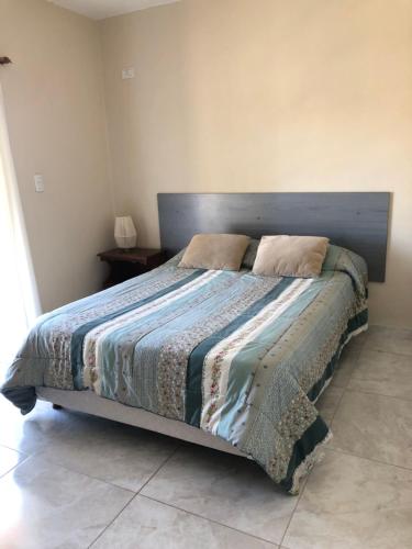 a bedroom with a large bed with a wooden headboard at Duplex Boulevard in Viedma