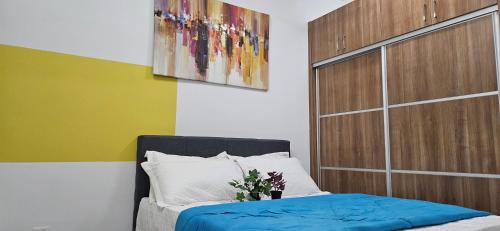 a bedroom with a bed and a painting on the wall at 2 Bedroom with Balcony Nearest KLIA in Sepang
