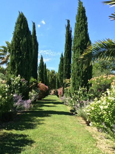a garden with trees and grass and flowers at HOTEL et APPARTEMENTS DOMAINE DES CLOS - Teritoria in Beaucaire