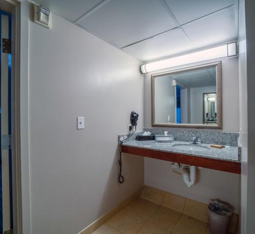 a bathroom with a sink and a mirror at Country Inn & Suites by Radisson, Ontario at Ontario Mills, CA in Ontario