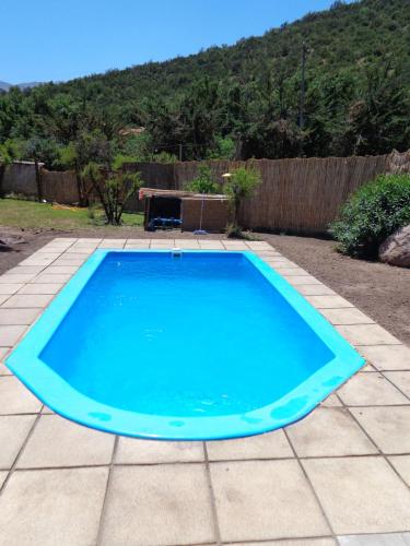 uma grande piscina azul num pátio em Cabañas Ciprés em Guayacán
