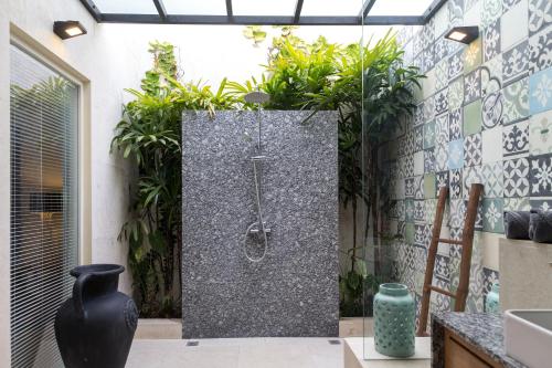 a shower in a bathroom with plants at Villa Cantik in Canggu