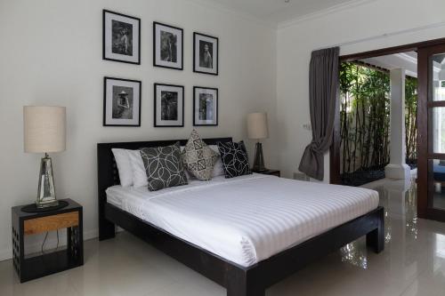 a bedroom with a bed with black and white pillows at Villa Cantik in Canggu