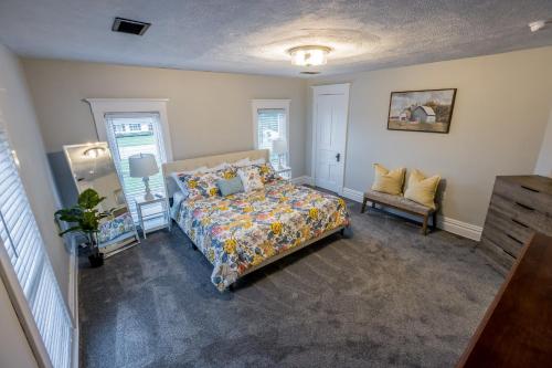 ein Schlafzimmer mit einem Bett und einem Stuhl darin in der Unterkunft Lakeside Vineyard Farmhouse in North East