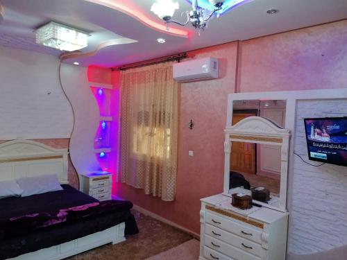 塔魯丹特的住宿－Riad Khadija: Relax & Explore，一间卧室配有一张床、镜子和电视